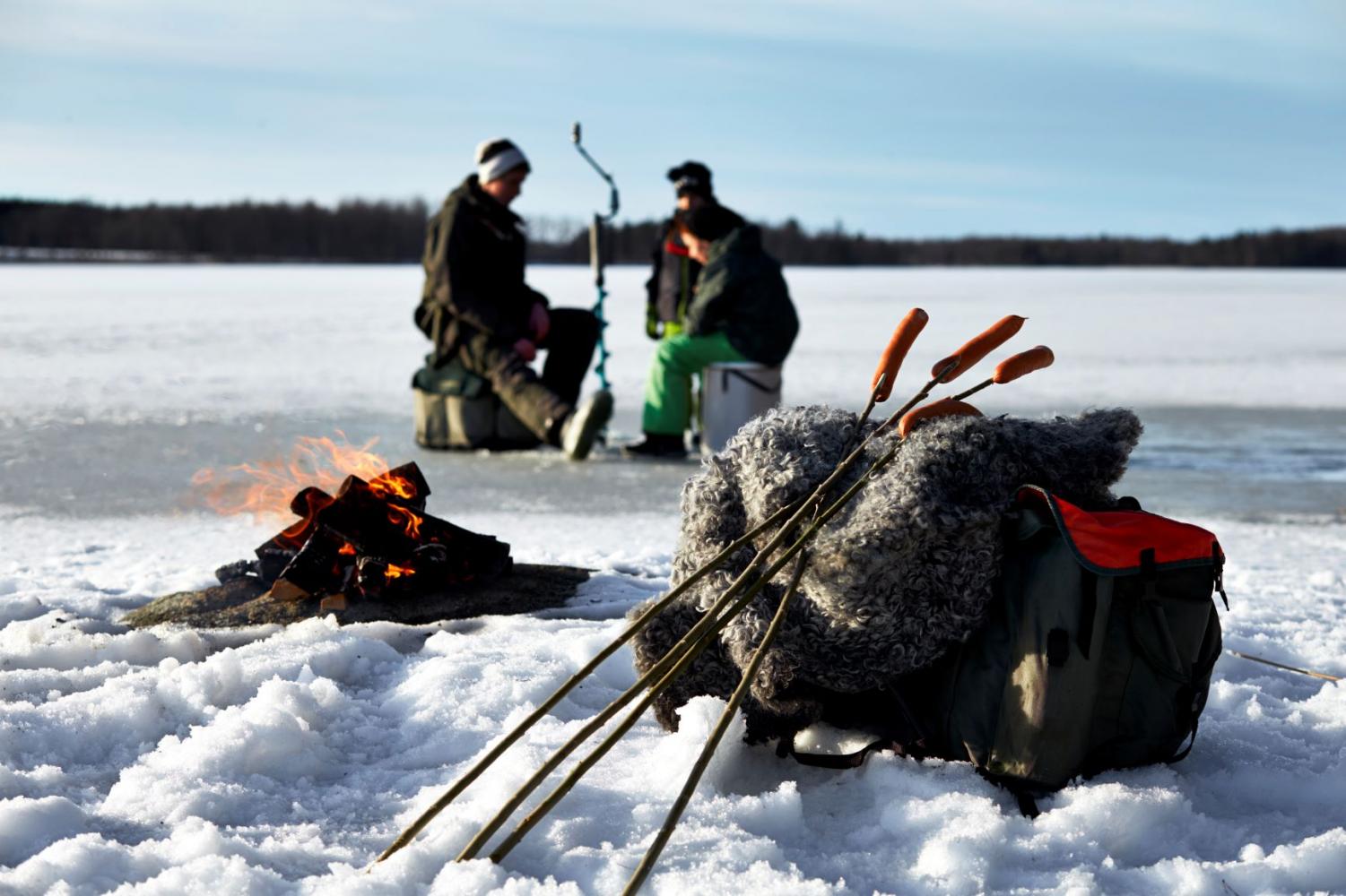 Fiskare på isen som tänt en bra för att grilla